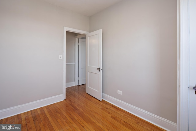 spare room featuring light wood finished floors and baseboards