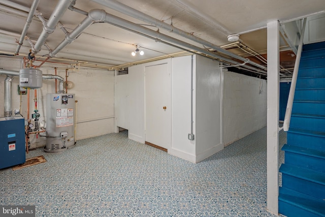 unfinished below grade area featuring water heater and a heating unit