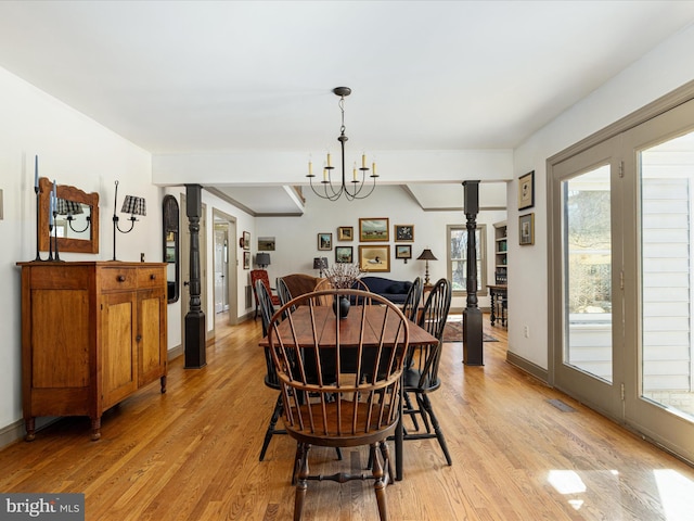 dining room featuring visible vents, light wood-style flooring, decorative columns, baseboards, and a chandelier