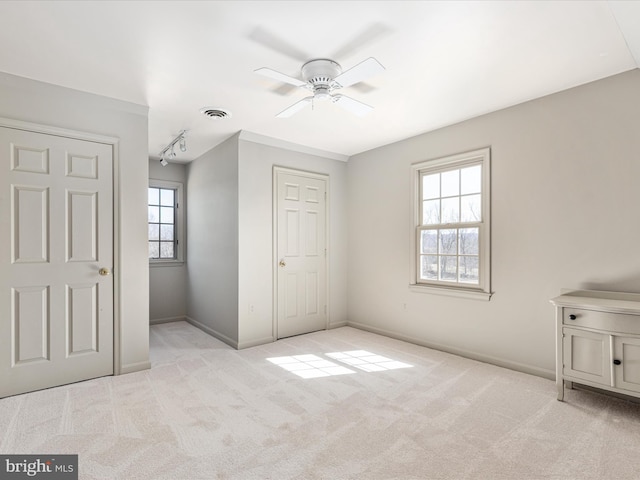 unfurnished bedroom featuring light colored carpet, visible vents, and baseboards