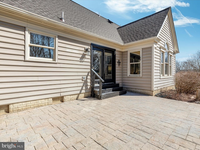 rear view of property featuring a shingled roof, a patio area, entry steps, and crawl space