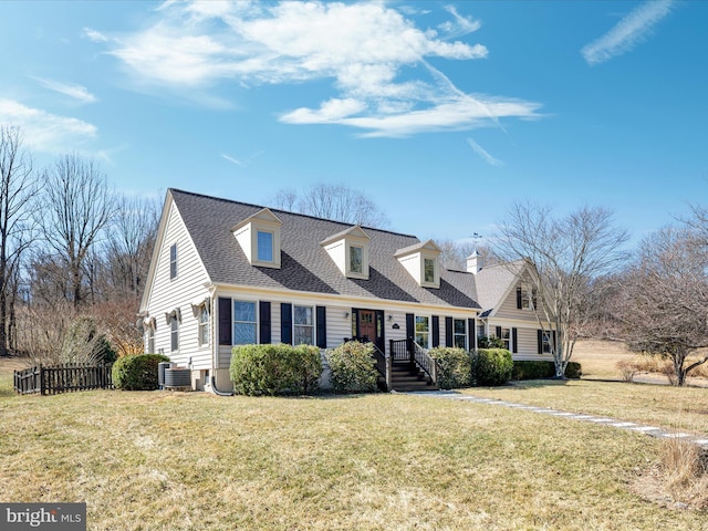 new england style home with central air condition unit, a shingled roof, a front lawn, and fence