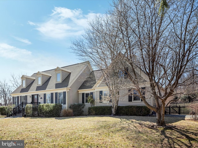 view of front of property featuring roof with shingles, a front yard, and fence