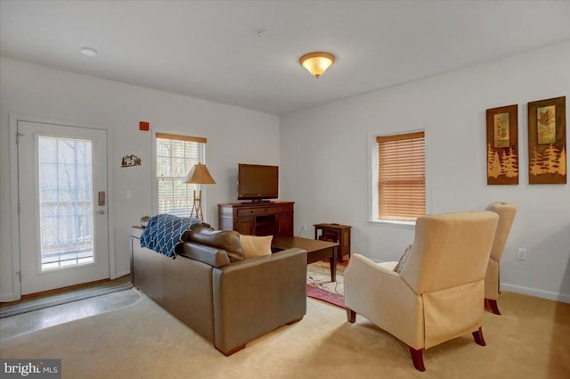 living area with light colored carpet and baseboards