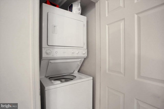 washroom with stacked washer and dryer and laundry area