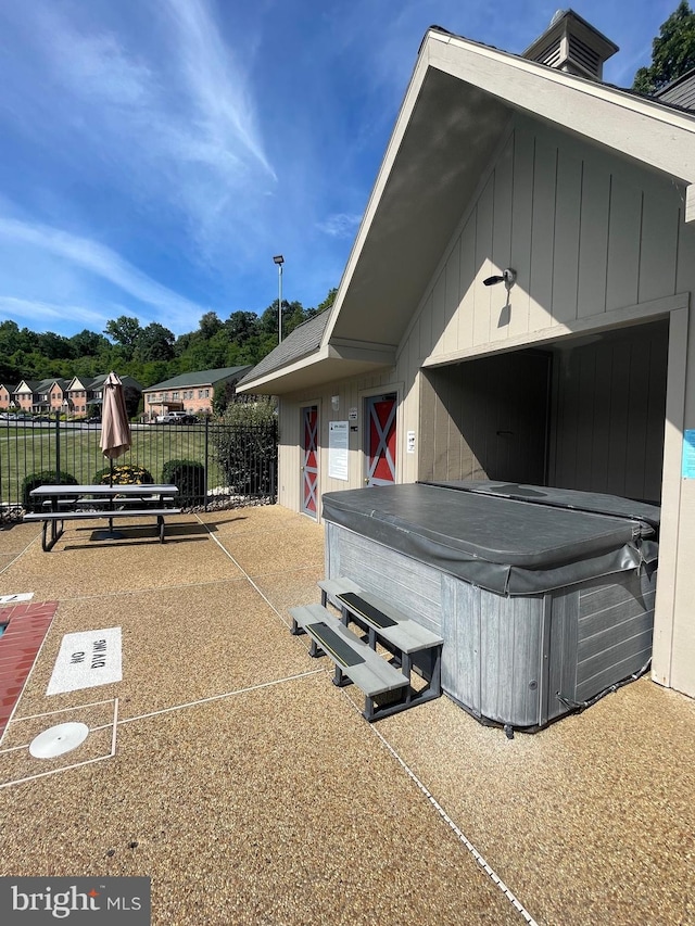 exterior space with a patio area, fence, and a hot tub