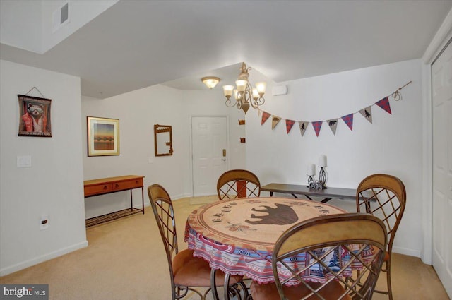 carpeted dining area featuring baseboards, visible vents, and a notable chandelier