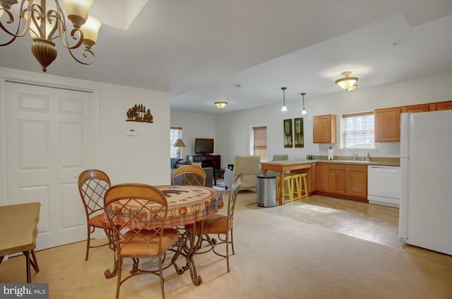 dining space with light carpet and a chandelier