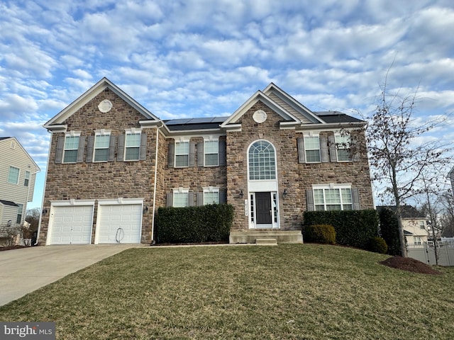 view of front of property with an attached garage, concrete driveway, a front lawn, and solar panels