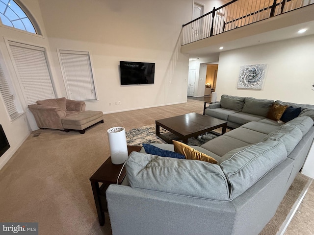 living area featuring recessed lighting, baseboards, and a high ceiling