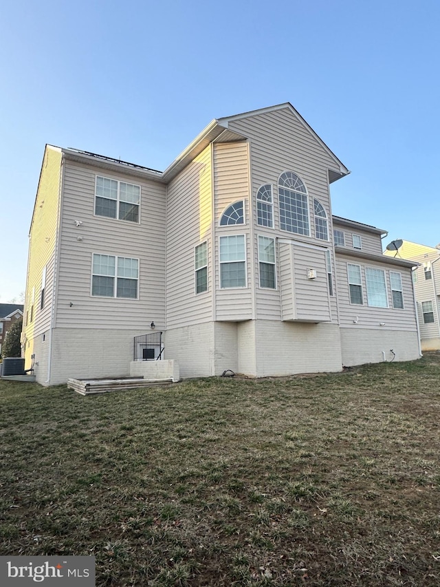 back of house with cooling unit and a yard