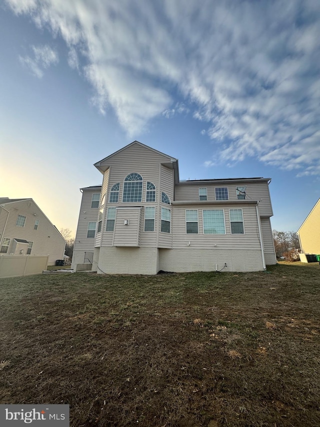 rear view of house with a yard and fence