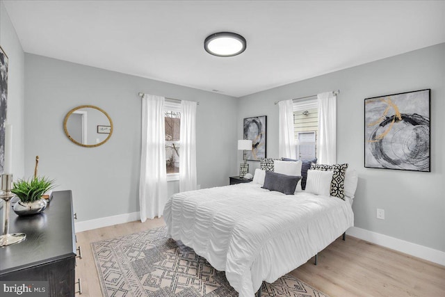 bedroom with light wood finished floors and baseboards