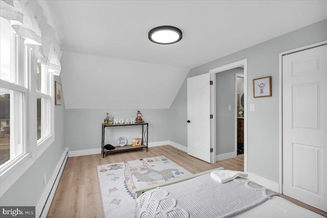 bonus room featuring lofted ceiling, light wood finished floors, baseboard heating, and baseboards