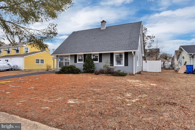 view of front of home featuring a shingled roof, a chimney, and fence