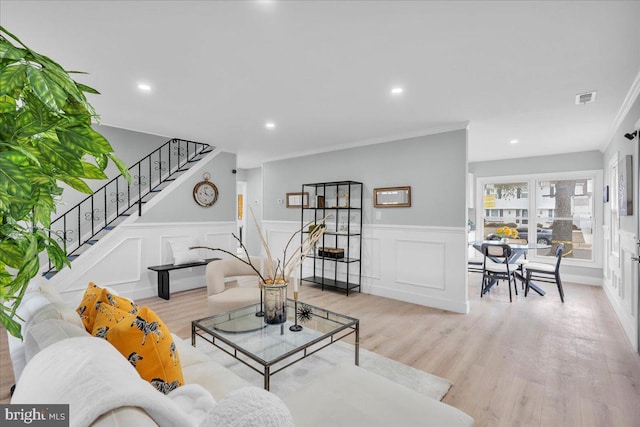 living area with recessed lighting, visible vents, ornamental molding, wood finished floors, and stairs