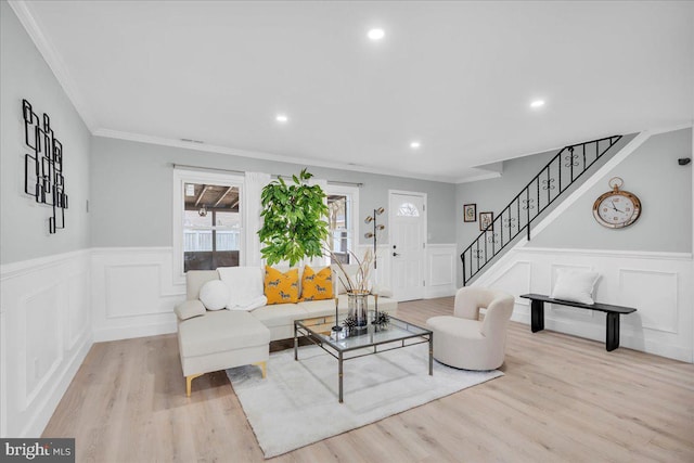 living area featuring stairway, wood finished floors, and ornamental molding