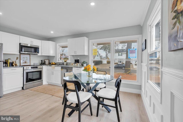 kitchen featuring stainless steel appliances, recessed lighting, white cabinetry, and light wood finished floors