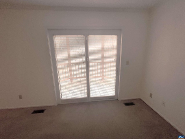 unfurnished room featuring carpet, visible vents, and baseboards