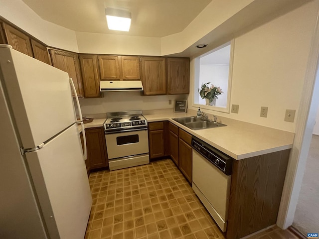 kitchen featuring white appliances, extractor fan, a sink, and light countertops