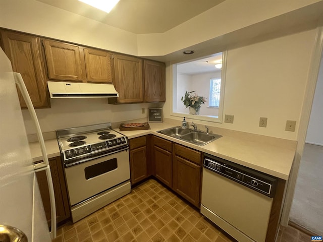 kitchen featuring white appliances, extractor fan, a sink, and light countertops