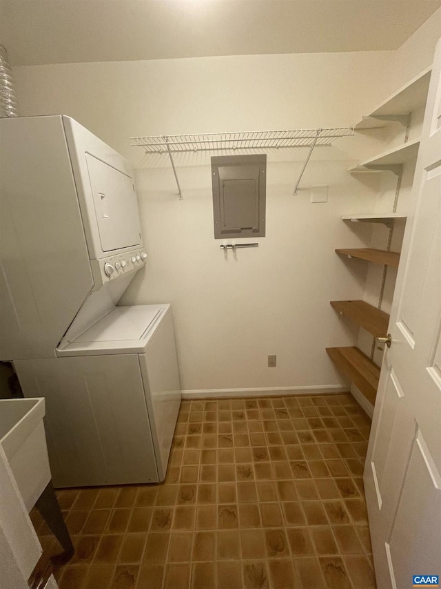 laundry area with stacked washing maching and dryer, baseboards, electric panel, and laundry area