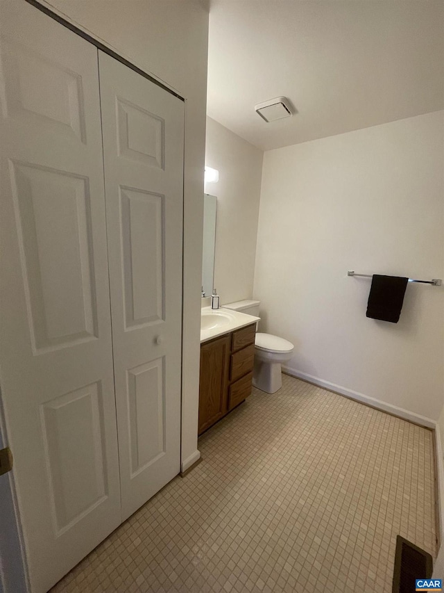 bathroom featuring baseboards, vanity, and toilet