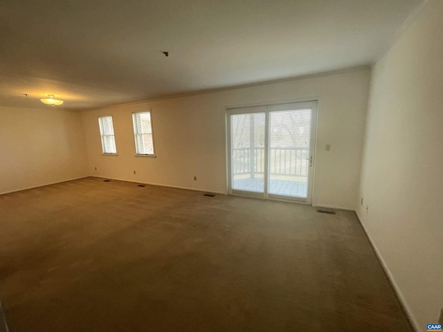 spare room featuring carpet and baseboards