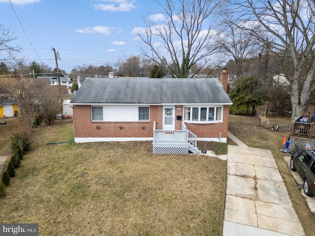 single story home with a front yard, brick siding, and a chimney