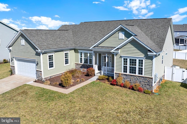 view of front facade with stone siding, a front yard, and driveway