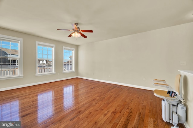 unfurnished living room with a ceiling fan, baseboards, and hardwood / wood-style floors