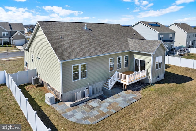 back of property featuring a patio area, a lawn, a fenced backyard, and roof with shingles