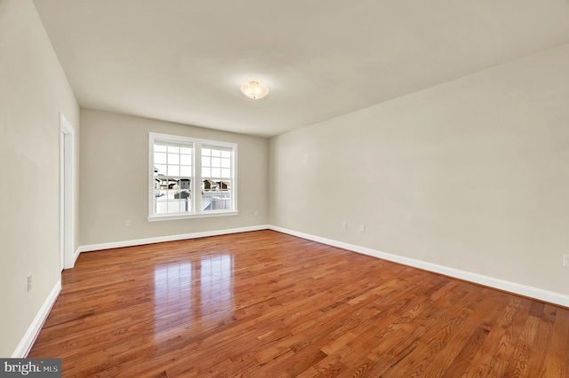 empty room with baseboards and wood finished floors