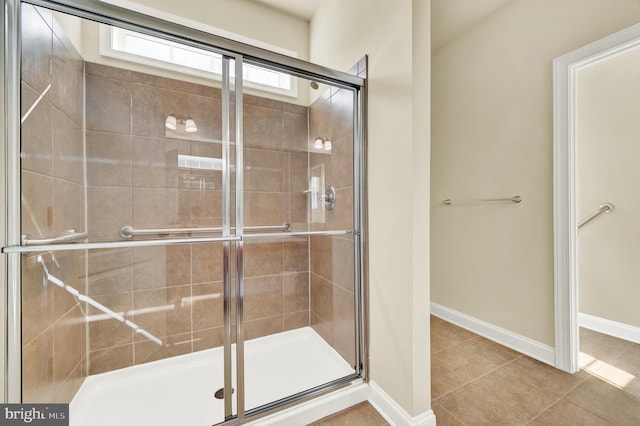 bathroom featuring a shower stall, baseboards, and tile patterned floors