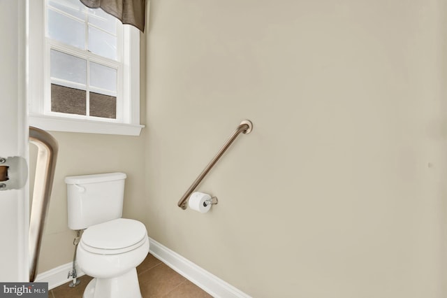 bathroom with toilet, tile patterned flooring, and baseboards