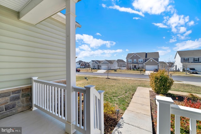 view of yard featuring a porch and a residential view