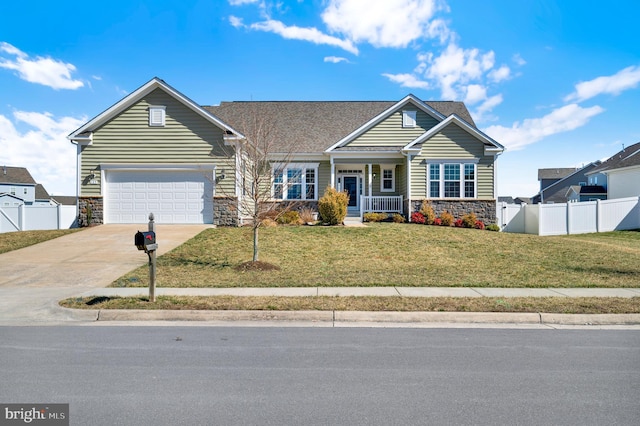 view of front facade featuring a garage, fence, stone siding, driveway, and a front lawn