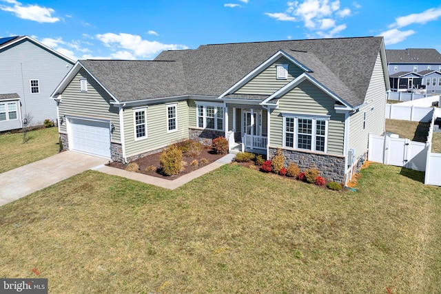 view of front of property featuring driveway, stone siding, a gate, fence, and a front yard