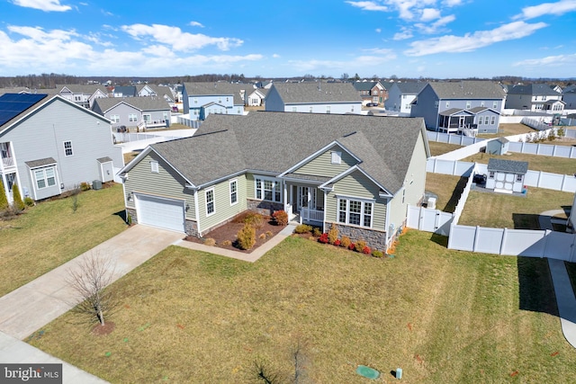 view of front of property featuring stone siding, concrete driveway, and a residential view