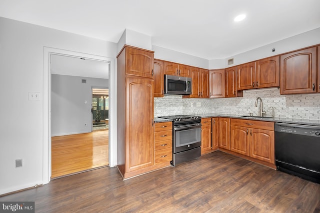 kitchen with electric range, a sink, black dishwasher, stainless steel microwave, and dark wood finished floors