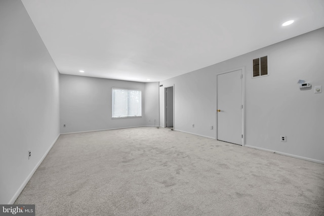 spare room featuring carpet, visible vents, and baseboards