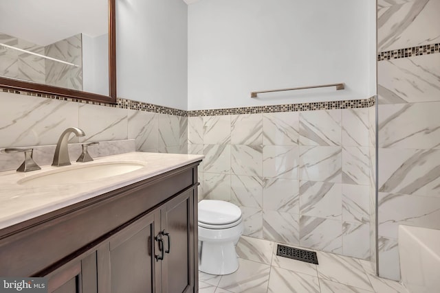 full bath featuring marble finish floor, visible vents, toilet, a tile shower, and vanity