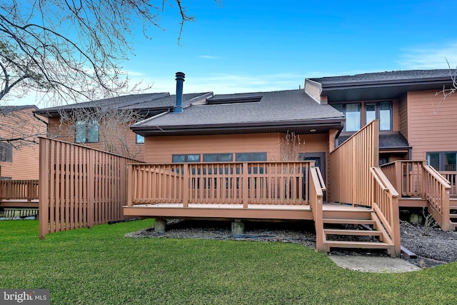 rear view of property with a shingled roof, a lawn, and a wooden deck