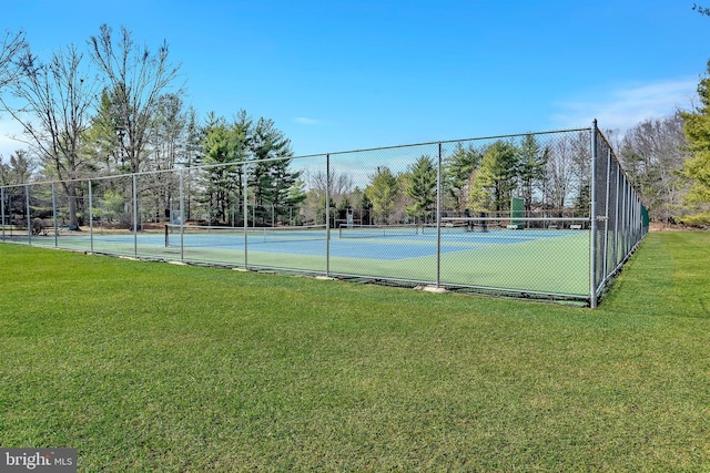 view of sport court featuring a yard and fence