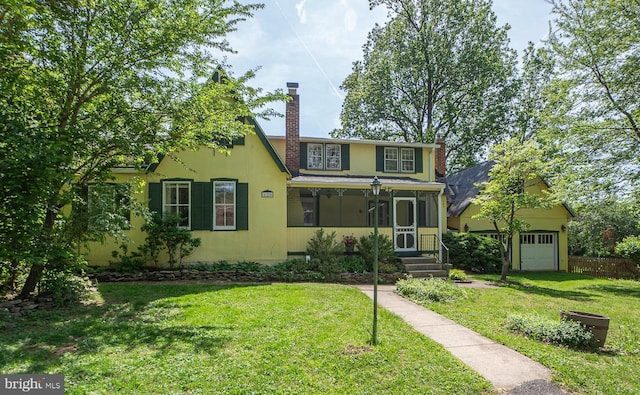 view of front of home featuring fence, a chimney, and a front lawn