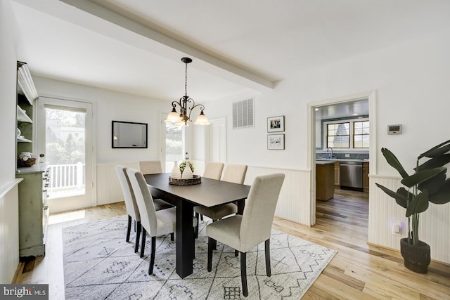dining area featuring a wainscoted wall, plenty of natural light, a notable chandelier, and visible vents