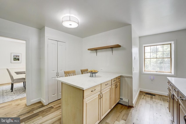 kitchen featuring visible vents, open shelves, baseboard heating, baseboards, and light wood-style floors