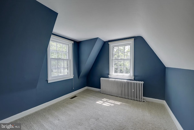 bonus room with visible vents, carpet, radiator heating unit, and vaulted ceiling