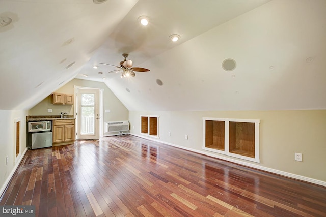 additional living space featuring a wall mounted air conditioner, a sink, baseboards, dark wood-style floors, and lofted ceiling