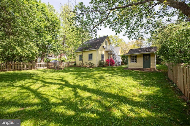 view of yard featuring a fenced backyard and an outbuilding